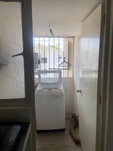 a room with a small refrigerator and a window at DEPA IXTLAN alberca y cerca de playa in Santa Cruz Huatulco