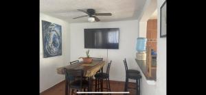 a dining room with a table and chairs and a ceiling fan at DEPA IXTLAN alberca y cerca de playa in Santa Cruz Huatulco +9 photos