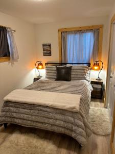 a bedroom with a large bed with two lamps at Bozeman Bungalow Downtown in Bozeman