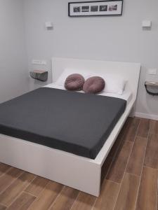a white bed with two brown pillows on it at Apartments by the sea Nin, Zadar - 23664 in Nin