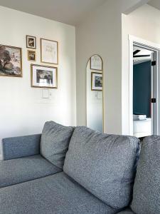 a gray couch in a living room with a mirror at StayAE Downtown - One Bedroom, 2nd Floor in Baton Rouge