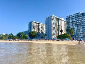 una playa con edificios y gente en la playa en Ocean View apt on Isla Verde in a 14th floor, en San Juan