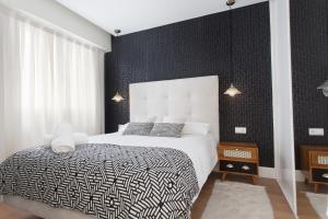 Passeig de Gracia Apartment في برشلونة: غرفة نوم بسرير بجدار اسود