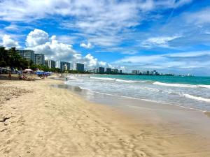 a beach with the ocean and buildings in the background at Private Apartment at Maré St Clair Hotel in San Juan +54 photos