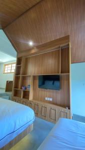 a bedroom with a bed and a flat screen tv at Calma La Barka Resort by Raminten in Moyudan