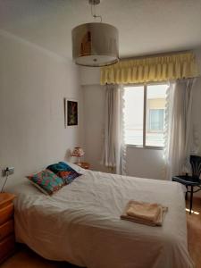 a bedroom with a white bed with a window at Apartamento en Alicante, Plaza de España, zona Mercado, AA in Alicante