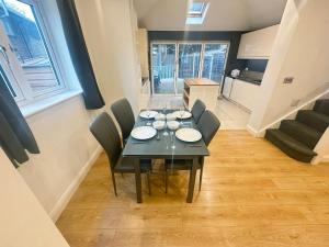 a dining room with a black table and chairs at Exquisite Home Away From Home in Greenford