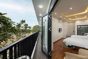 a bedroom with a balcony with a bed and a table at Success Airport Hanoi Hotel in Phu Lo Dong +50 photos