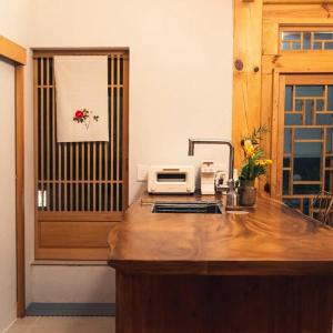 a kitchen with a counter with a sink and a microwave at Hanok Prince in Gyeongju +26 photos