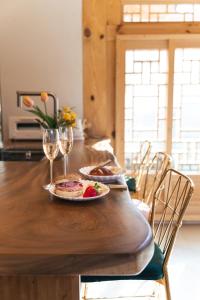 a wooden table with a plate of food and wine glasses at Hanok Prince in Gyeongju