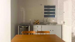 a kitchen with a wooden table and two chairs at Casa com 3 dormitórios na Praia do Sonho in Itanhaém