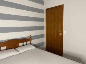 a bedroom with a bed and a wooden door at Casa com 3 dormitórios na Praia do Sonho in Itanhaém