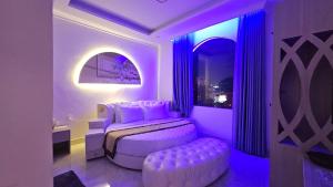 a bedroom with a bed and a purple lighting at Lucky Hotel Uông Bí in Uông Bí