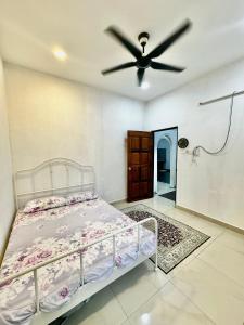 a bedroom with a bed and a ceiling fan at Rumah D Hutan in Kampong Cheh