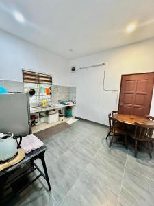 a room with a table and a kitchen with at Rumah D Hutan in Kampong Cheh