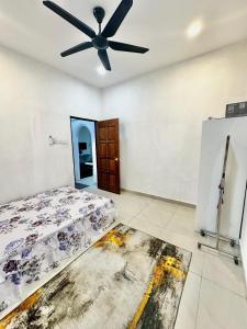 a bedroom with a bed and a ceiling fan at Rumah D Hutan in Kampong Cheh +2 photos