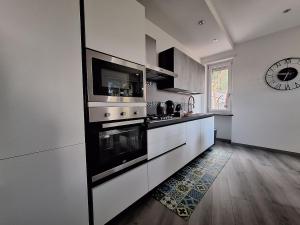 Una gran cocina blanca con fogones y microondas. en Villa della Quiete, en San Mauro Torinese