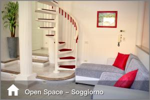 a living room with a spiral staircase with red pillows at La Colonna - 350m dalla Spiaggia, Sardegna in Portoscuso