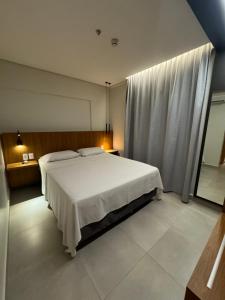a bedroom with a white bed and a window at Apto Premium Resort in Salinópolis +21 photos