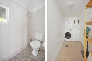 a bathroom with a toilet and a washing machine at White Sands Retreat, Hyams Beach in Hyams Beach +7 photos