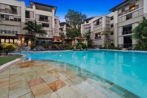 a large swimming pool in front of two apartment buildings at Temple 2 Bedroom Penthouse in Palm Cove +1 photo
