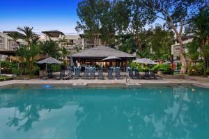 a swimming pool with chairs and a gazebo at Temple 2 Bedroom Penthouse in Palm Cove