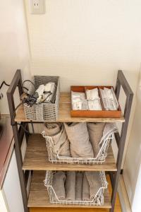 a shelf with towels and baskets on it at 最大5人で泊れる宿 新潟駅から徒歩7分 ペット同伴可 in Niigata