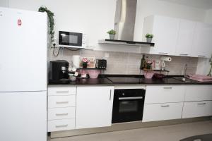 a kitchen with white cabinets and a black appliance at Alicantan Vital Experience in Alicante