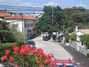 a red car parked on a street with red flowers at Guesthouse Villa Galovic in Brseč +43 photos