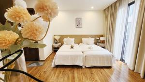 a bedroom with a white bed and a large window at YLY Lotus in Ha Long