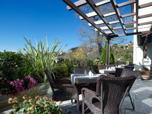 un patio con mesas y sillas bajo una pérgola en Stevalia Hotel & Spa en Portariá