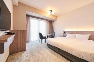 a hotel room with a bed and a desk at Hotel Grand Tiara Minaminagoya in Anjomachi