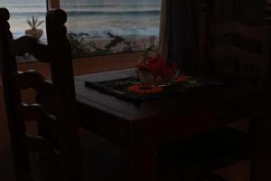 une table avec un bol de fleurs et une fenêtre dans l'établissement Casa Costa Azul, à San José del Cabo