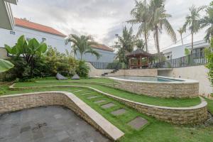 Un jardín con piscina y una casa. en The Beautiful villa, Casa Sara, en Canggu