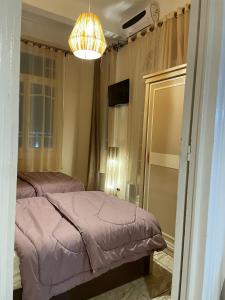 sypialnia z 2 łóżkami i żyrandolem w obiekcie شقه مفروش w Aleksandrii +7 zdjęć