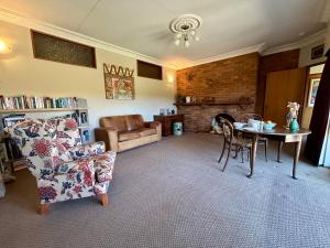 a living room with a couch a table and a chair at Castle Dent - exclusive guest suite in Lawrence