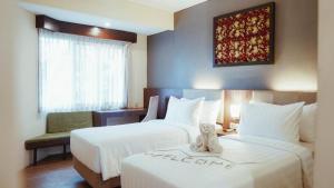 Postel nebo postele na pokoji v ubytování Tuwuh Hotel at Kayutangan