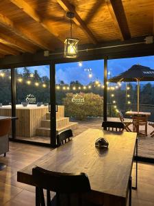 グアタペにあるGRETEL CHALETS SUIZOの大きな木製テーブル(椅子付)、大きな窓
