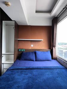 une chambre avec un lit avec des draps bleus et une fenêtre dans l'établissement Raja Apartemen Jarrdin Type 33, à Bandung