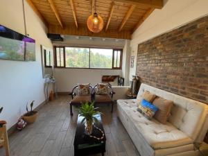 a living room with a couch and a brick wall at VILLA DE MOYA HOTEL MONGUI in Monguí
