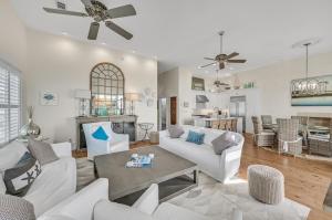 a living room with white furniture and a table at Emerald View on 30A in Santa Rosa Beach