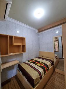 a small bedroom with a bed and a mirror at Amira Homestay Mataram in Tjakranegara