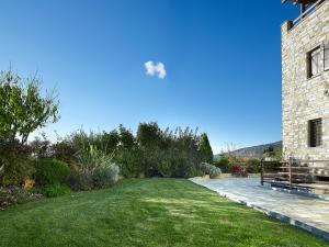 a grassy yard next to a brick building at Stevalia Hotel & Spa in Portaria