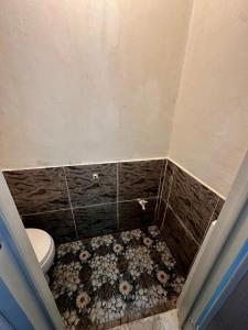 a bathroom with a toilet and a tiled floor at Bgs Place Moalboal in Moalboal