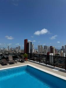 a swimming pool on top of a building with a city skyline at Paraíso em Tambauzinho in João Pessoa