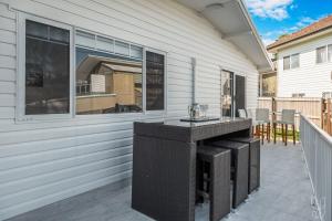 een patio in de achtertuin met een bar aan de zijkant van een huis bij Serenity Cottage Beach Escape in Yeppoon