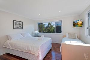 een slaapkamer met twee bedden en een raam bij Serenity Cottage Beach Escape in Yeppoon +26 foto's