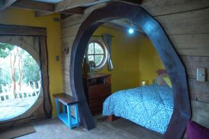 een slaapkamer met een bed en een gewelfd raam bij Cabañas Quetalmahue in Ancud