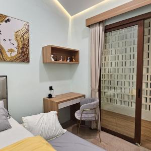 a bedroom with a desk and a bed and a chair at 3 Bedroom House Near Grand Batam Mall in Bagam