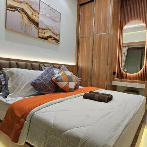 a bedroom with a bed with an orange and white blanket at 3 Bedroom House Near Grand Batam Mall in Bagam